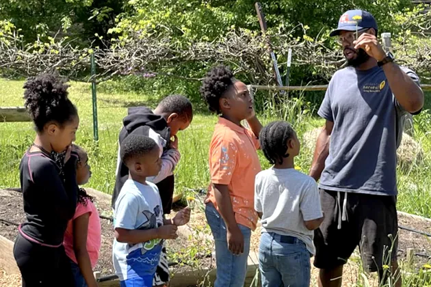 A group of children in a garden learning about Earth Day.
